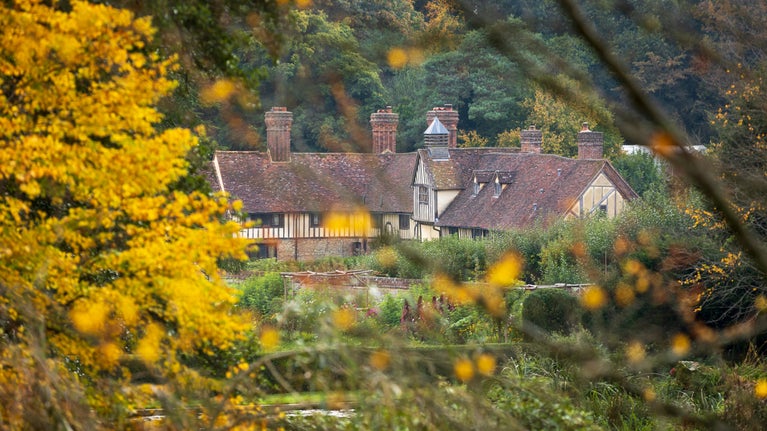 Autumn view of the gardens and Mote Cottages at Ightham Mote, Kent NT1G6OT